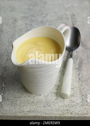 Petit pot contenant de sauce hollandaise Banque D'Images