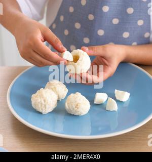 Insertion de la mozzarella dans la boule de riz Banque D'Images