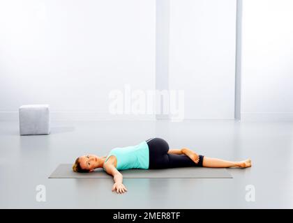 Femme pratiquant le yoga sur tapis Banque D'Images