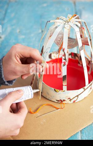 Fabrication d'une cage à oiseaux en papier, collage sur les côtés Banque D'Images