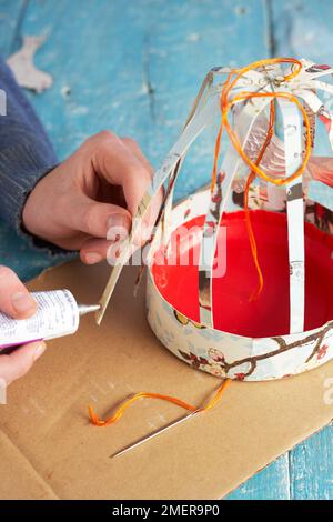 Fabrication d'une cage à oiseaux en papier, collage sur les côtés Banque D'Images