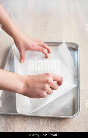 Revêtement de la plaque de cuisson avec du papier parchemin Banque D'Images