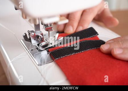 Fixez la bande Velcro sur la doublure et la partie supérieure matelassée de la veste pour chien pour y attacher la bande Velcro Banque D'Images