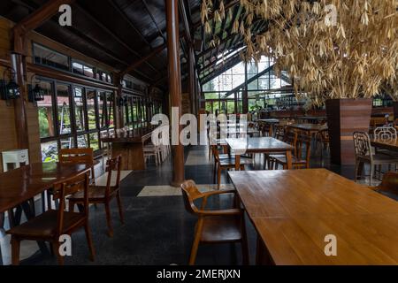 Intérieur de café avec tables et chaises en bois au milieu du paysage de la nature Banque D'Images