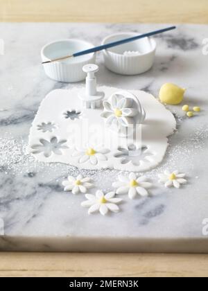 Les fleurs coupées à partir de sucre glace à l'aide de cutters façonnés et saupoudrées de sucre glace Banque D'Images