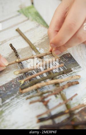 Mini-ferme jardin pour enfants, fabrication de clôture en bois à partir de brindilles Banque D'Images