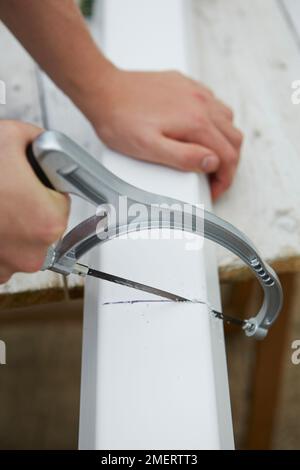 Scier la gouttière à la taille souhaitée Banque D'Images