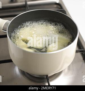 Pommes de terre cuisant à l'eau bouillante dans une casserole sur cuisinière Banque D'Images