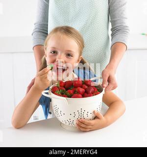 Fille et grande passoire de fraises, 5 ans Banque D'Images