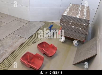 Tiler a appliqué l'adhésif pour carreaux et colle sur les nouveaux carreaux, Hesse, Allemagne Banque D'Images