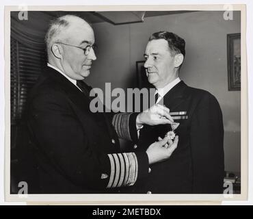 L'amiral Joseph F. Farley, commandant de la Garde côtière, présente la Légion du mérite au contre-amiral James Pine, surintendant de l'Académie de la Garde côtière. Washington, D.C.---l'amiral Joseph F. Farley, commandant de la Garde côtière, a présenté la Légion du mérite au contre-amiral James Pine, surintendant, Académie de la Garde côtière, on 28 mars 1946, Au siège de la Garde côtière, Washington, D.C. La médaille a été décernée au contre-amiral Pine par James Forrestal, secrétaire de la Marine, en reconnaissance de son «leadership, compétence professionnelle, excellente planification et dévouement exceptionnel au devoir dans la formation de milliers d'officiers et Banque D'Images