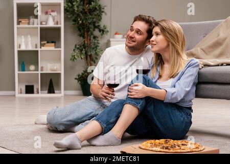 Couple regardant la télévision boire du vin Banque D'Images