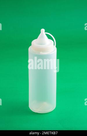 Distributeur de conteneurs sauce plastique ; photo sur fond vert. Banque D'Images