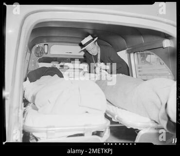 SS ANDREA DORIA - SS STOCKHOLM COLLISION. Un prêtre non identifié administre les derniers rites de l'Église catholique à un homme gravement blessé du SS STOCKHOLM dans une ambulance en route vers l'hôpital public de services de santé à Brighton, Massachusetts. Banque D'Images