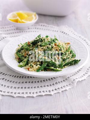 Couscous de légumes avec des mangeouts, des asperges, des pignons de pin, des herbes et du citron Banque D'Images