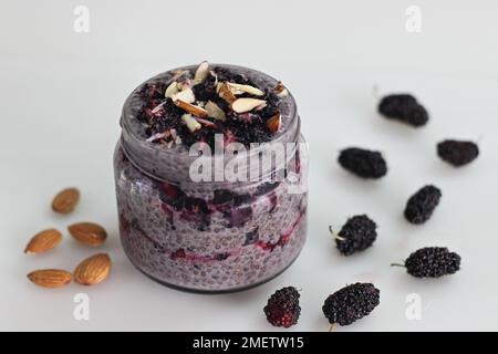 Une nuit de pudding au Chia Oats servi avec des mûres et des amandes hachées. Un petit déjeuner sain sans cuisine. Prise de vue sur fond blanc le long de W Banque D'Images