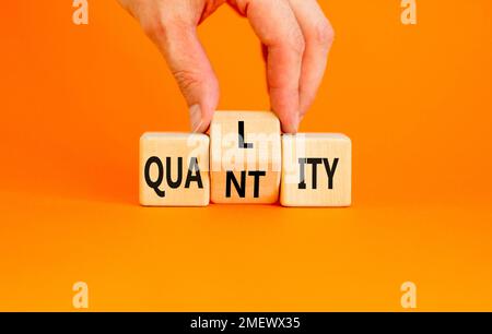 Symbole de qualité et de quantité. Concept Word qualité quantité sur cubes en bois. Main d'homme d'affaires. Belle table orange fond orange. Business et q Banque D'Images