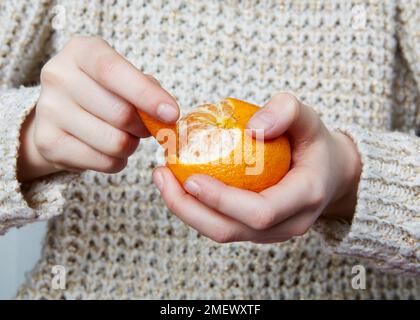 Peler une orange enfant Banque D'Images