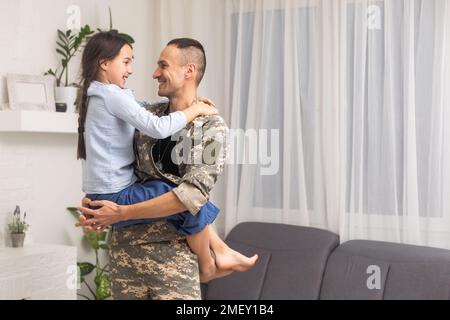 père militaire embrassant sa fille. Banque D'Images