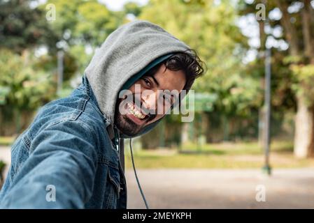 Suivez-moi concept. Un jeune homme souriant marchant dehors tenant la main de sa petite amie. L'homme dirige la femme. Banque D'Images