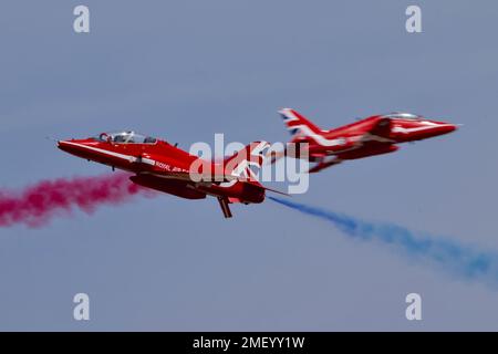 Un cliché sous angle du croisement de la RAF Red Arrows Syncro pair au Royaume-Uni Banque D'Images