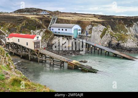 St Davids, Pembrokeshire, pays de Galles - Mars 2022: Nouvelles et anciennes stations de canot de sauvetage et de cale sur la côte rocheuse de Pembrokeshire. Banque D'Images