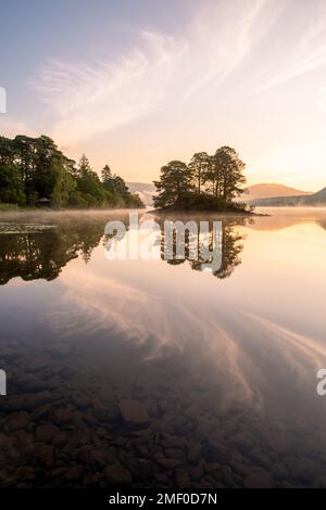 Reflets de lever de soleil d'été à Derwentwater, Manesty Island, Keswick, Lake District, Royaume-Uni. Banque D'Images