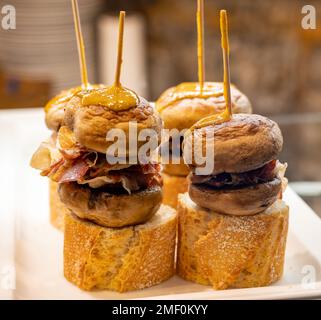 En-cas typique du pays basque, brochettes de pinchos ou de pinxtos avec petits morceaux de pain, champignons et fromage servis au bar de San-Sebastian ou Bilbao, Banque D'Images