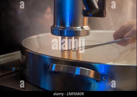 Machine pour préparer des crosses de desserts espagnols sur le marché de Noël nocturne à Bilbao, en Espagne Banque D'Images