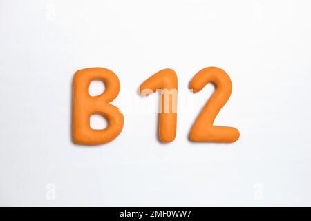 Concept de supplémentation en vitamine B12. Couleur orange du signe tridimensionnel sur fond blanc. Symbole de cobalamine important comme soutien de la santé et par v Banque D'Images