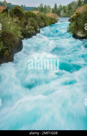 Eau en mouvement de longue exposition des chutes Huka eau qui coule rapidement dans les gorges couvertes de brousse à Taupo, en Nouvelle-Zélande. Banque D'Images