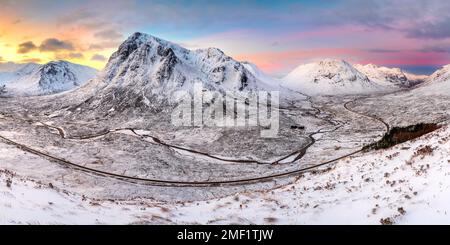 Vue panoramique aérienne des montagnes enneigées de Glencoe au lever du soleil. Buachaille, Highlands écossais, Royaume-Uni. Banque D'Images