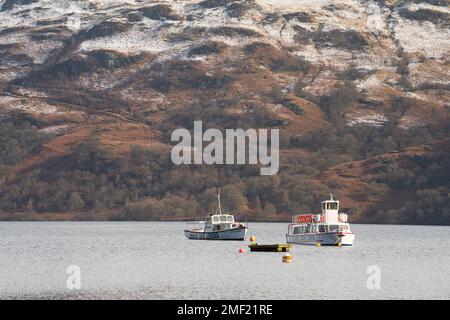 Deux bateaux de croisière Loch Lomond sur le lac avec des montagnes enneigées en arrière-plan. Banque D'Images