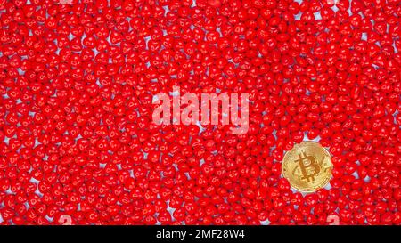 Pièce de monnaie Bitcoin d'or sur fond de bonbons en forme de cœur rouge. Le prix de la valeur de la crypto-monnaie Bitcoin baisse, baisse, tableau rouge des actions. Crypto-monnaie douce Banque D'Images