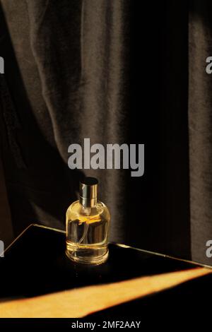Une bouteille de parfum sur fond noir Banque D'Images