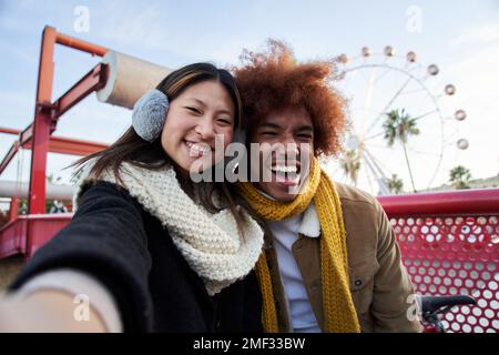 Jeune couple de course mixte en vêtements d'hiver prenant un selfie à l'extérieur. Banque D'Images