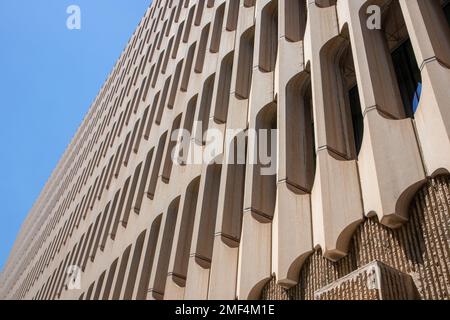 Architecture moderne dans le style du brutalisme. Fragment d'un bâtiment en béton regardant de dessous en perspective contre un ciel bleu. Nouveau Brutalis Banque D'Images