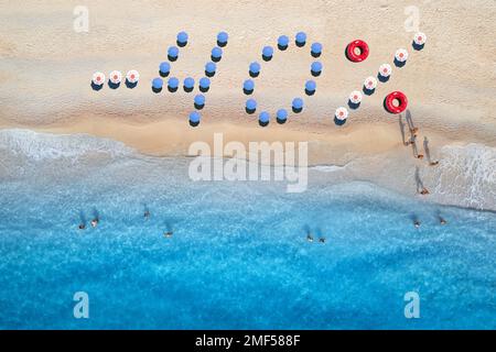 Texte créatif - 40 en parasols colorés sur une plage de sable Banque D'Images