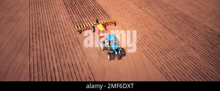 Un tracteur avec un semoir sur la vue de drone de champ, la saison de printemps de la campagne de semis. Banque D'Images