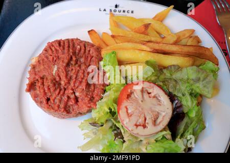 Steak tartare aka tartare de boeuf avec des frites et de la salade, un plat traditionnel français servi dans le restaurant la Source.Paris.France Banque D'Images