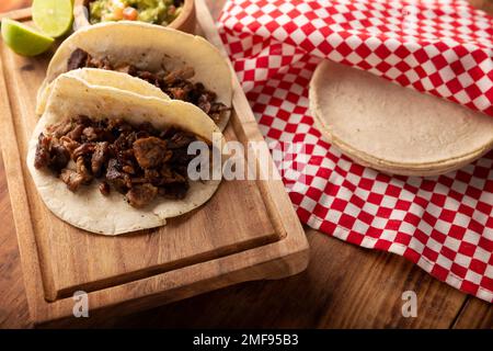 Tacos de Bistec. Viande grillée maison dans une tortilla au maïs. Cuisine de rue du Mexique, traditionnellement accompagnée de coriandre, d'oignon et de sauce épicée ou Banque D'Images