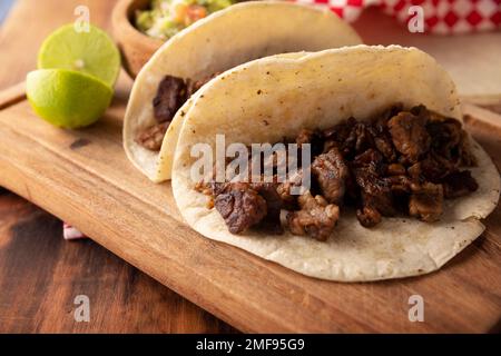 Tacos de Bistec. Viande grillée maison dans une tortilla au maïs. Cuisine de rue du Mexique, traditionnellement accompagnée de coriandre, d'oignon et de sauce épicée ou Banque D'Images