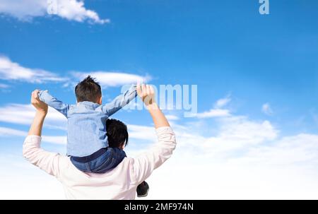 Père donnant son fils pigegyback sur ses épaules et regardant le nuage Banque D'Images