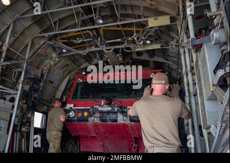 ÉTATS-UNIS Des aviateurs du 75th e Escadron de transport aérien expéditionnaire et du 726th e Escadron de la base aérienne expéditionnaire chargent un camion d'incendie remis à neuf sur un Hercules C-130 sur la ligne de vol du Camp Lemonnier, à Djibouti, le 18 août 2022. Ce camion d'incendie est le dernier des trois camions au total qui ont volé et livré à un endroit éloigné de la Corne de l'Afrique pour accroître les capacités opérationnelles. (Photo des États-Unis Air Force SSgt Branden Rae) Banque D'Images