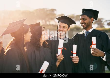 Cette année est si fière d'être diplômée. un groupe d'étudiants célébrant avec leurs diplômes le jour de la remise des diplômes. Banque D'Images