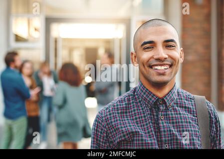 J'ai hâte de poursuivre mes études. Portrait d'un jeune homme heureux debout à l'extérieur sur le campus. Banque D'Images