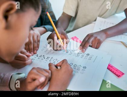 L'école, les enfants et les mains écrivent pour le travail d'équipe avec l'activité d'apprentissage dans le groupe de classe ensemble. Jeunes enfants et étudiants travaillant sur l'alphabétisation et Banque D'Images