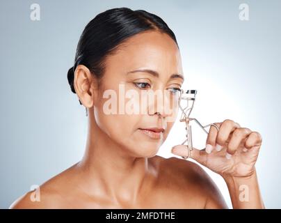 Visage, beauté et femme avec fard à paupières en studio isolé sur un fond gris. Cosmétiques, maquillage et mature et belle tenue de modèle de femme Banque D'Images