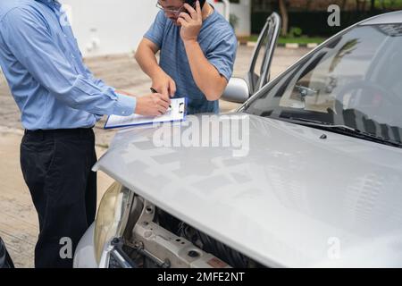 L'agent d'assurance rédige le rapport de réclamation d'assurance dans le presse-papiers pendant l'assurance. Processus de réclamation de l'agent d'assurance et de l'agent d'assurance après un accident de voiture Banque D'Images