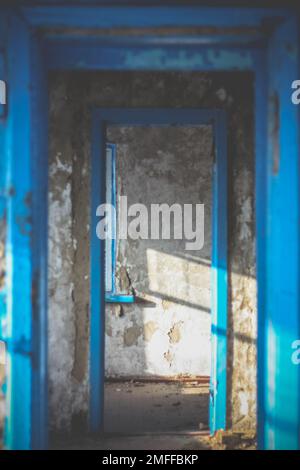 Couloir étroit à l'intérieur d'un bâtiment abandonné éclairé par la lumière du soleil concept photo Banque D'Images